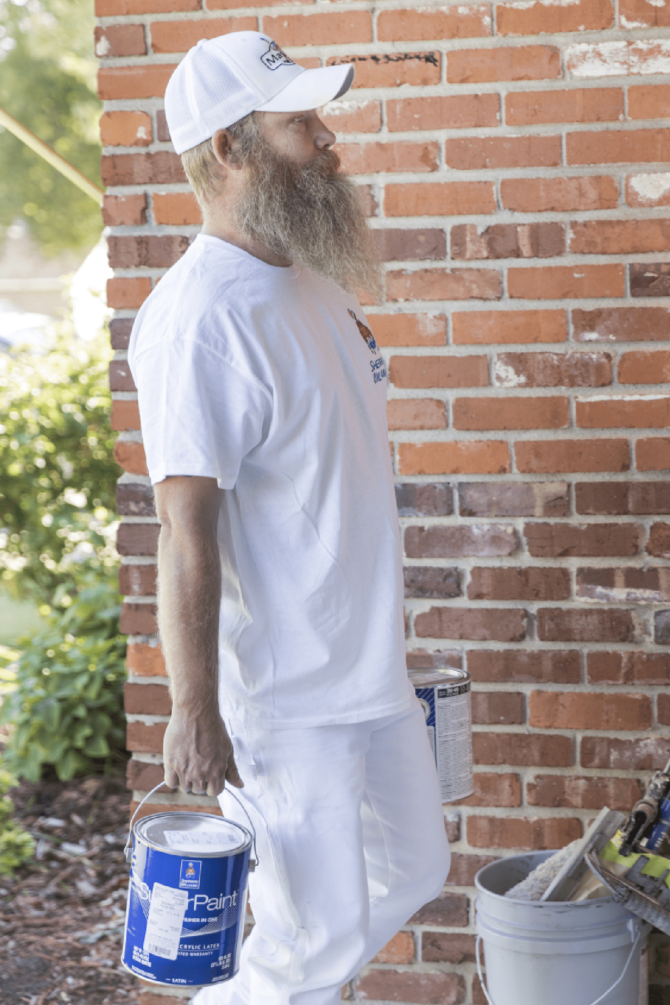 A man carring two paint bucket with his hand